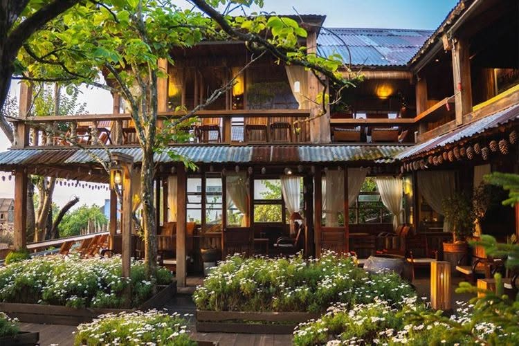 Nhà gỗ giữa cây xanh và hoa